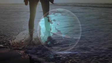 Gün batımında suya giren bir kadın, dönen bir holograma neden oluyor. Veri akışlarını görselleştiriyor. Gelecekçi, minimalist, ruhani, çevresel, teknoloji, refah, manzara