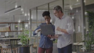 Kadın çalışanın, erkek meslektaşıyla dizüstü bilgisayarı dinleyerek ikili veri örtüsü oluşturması. İşbirliği, takım çalışması, yenilik, teknoloji, veri, dijital, modern