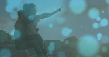 Günbatımında Bokeh 'in ortasında onu kucaklayan bir adam. Romantik, siluet, manzara, uyum, macera, sükunet, keşif