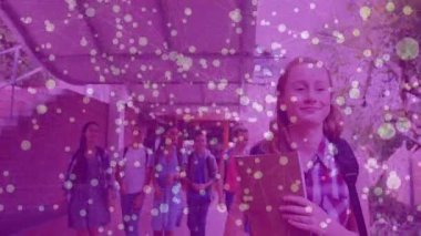 Okul kampüsünde sınıf arkadaşlarına liderlik eden genç bir kız. Durup arkadaşını selamlıyor. Gençler, arkadaşlık, işbirliği, açık hava, gençlik, eğitim, kampüs