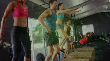 Spor salonunda spor salonu sinyali veriyor, atlama hareketleri yapıyor, hareketli sayaçlar olarak dambıl ütülüyor. Atletizm, takım çalışması, güç, koordinasyon, canlı, dinamik, motivasyon