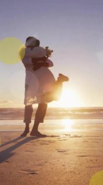 Afrika kökenli Amerikalı çiftin kumsalda evlenmesi üzerine ışıklı noktaların canlandırılması. Düğün günü, kutlama, birliktelik ve aşk konsepti dijital olarak oluşturulmuş video..