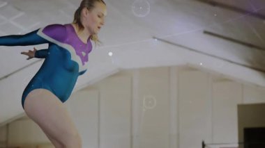 Jimnastikçi, jimnastik eğitiminde iz sürme yolunu kesiştirirken ayrık sıçramayı başlatıyor. Atletik, performans, disiplin, hareket, koreografi, zarafet, güç