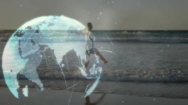 Alacakaranlıkta kumlu sahil şeridinde dans eden yetişkin bir kadın holografik küresel teknoloji gösterisini başlatıyor. Dijital, kavramsal, minimalist, fütürist, çevresel, dingin, yenilikçi