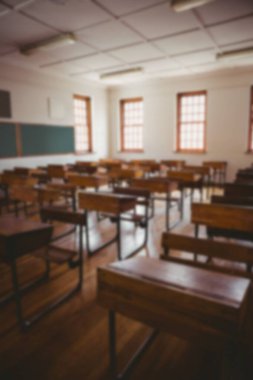 Empty wooden chairs and tables in classroom at university