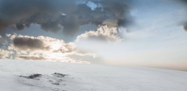 Karla kaplı düzlük düz dizaynlı dramatik bulutların altında geriliyor. Kış, manzara, yalnızlık, keşif, dinginlik, minimalist, doğal