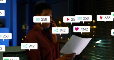 Düğmeli tişört giymek, akıllı telefon ve belgeleri analiz etmek ve gece ofiste tebligat yapmak. Teknoloji, iletişim, profesyonellik, analitik, modern, kentsel, dinamik