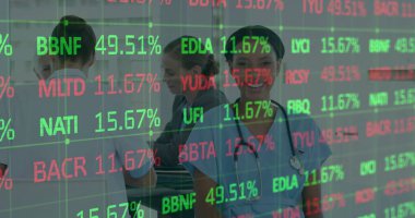 Steteskobu olan hemşire eğri büğrü hemşire istasyonunda kodları ve yüzdeleri gözden geçiriyor. Tıbbi ekip, sağlık, yenilik, profesyonel, işbirliği, teknoloji, klinik