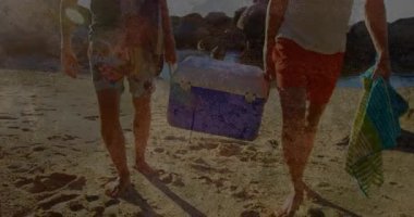 Kamera görüntülerinde iki arkadaşın mor soğutucu ve seyahat reklamında sörf tahtası ile kıyıda yürüdüğü görülüyor. Sahil, boş zaman, açık hava, macera, yaz, eğlence, yaşam tarzı.