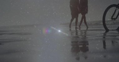 Çerçeveye giren gezgin arkadaşlar mercek altında ıslak kumda park halindeki bisikletlere doğru yürüyorlar. Deniz kıyısı, arkadaşlık, yansıma, rahatlık, dinginlik, açık hava, klasik.