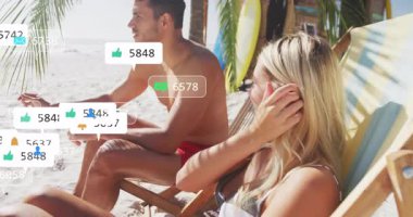 Plaj sandalyelerine yaslanan bir çift, artan nişanı gösteren sosyal medya baloncukları kazanıyor. Tropikal, boş zaman, rahatlama, açık hava, yaşam tarzı, canlı, bağlantı