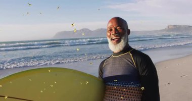 Sahilde sörf tahtası kaldıran bir adam, yıldız parçacıkları spor tanıtımı için sürüklenirken tahta burnunu ortaya çıkarıyor. Macera, rahatlama, canlılık, açık hava, sükunet, yaşam tarzı, manzara