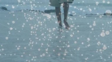 Sörf yapan ve kıyı şeridinde yürüyen bir adamı gösteren seyahat dalgalanmalara ve titreyen yansımalara neden olur. Sahil, sahil, su, dalgalar, yansıma, yalınayak, gündelik