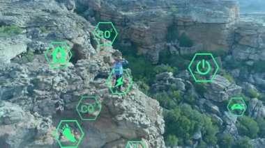 Gezgin, tarayıcıyla kanyon görüntüsünü tarıyor yüzen çevre simgelerini etkinleştiriyor keşfi yönlendiriyor. Macera, keşif, sürdürülebilirlik, teknoloji, vahşi doğa, açık hava, izleme