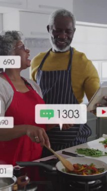 Afro-Amerikan çifti yemek pişirirken dijital tablet kullanıyor. Dijital bileşim, çoklu pozlama, aşk, birliktelik, sosyal medya ve teknoloji konsepti.