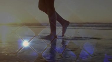 Ufuk altında ıslak kumsala ayak basan bir kadın, bacaklarının etrafında gezinen teknolojik elmasları çalıştırıyor. Deniz kıyısı, yansıma, sükunet, minimalizm, dinginlik, okyanus, rahatlık