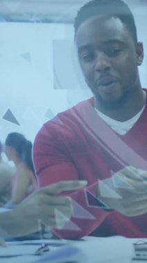 İki Afro-Amerikalı iş arkadaşı ofislerinde dizüstü bilgisayar kullanarak konuşuyorlardı. Çevreleri dijital teknolojiyle çevrili, bu da onlara küresel bir erişim sağlıyor. Çalışmalarının kapsamı çok geniş ve birçok veriyi çabucak işleyebiliyorlar..