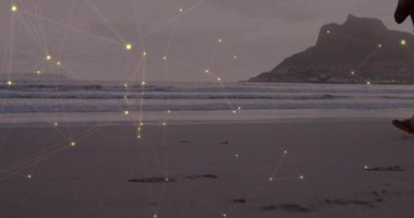 Koşucu kumun üzerine çıkıyor ve fitness takibi için koşarken ağ kaplamasını etkinleştiriyor. Atletik, teknoloji, hareket, açık hava, manzara, esneklik, yenilik