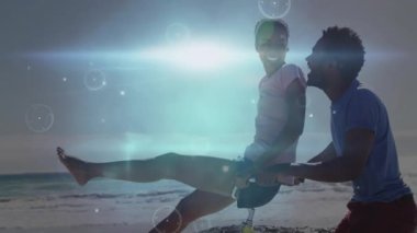 Kıyı şeridinde bisiklet süren bir adam, hareketli fişekler ve seyahat içeriğini zenginleştiren küreler gibi binen bir kadın. Macera, dostluk, enerji, canlı, açık hava, hareket, huzur