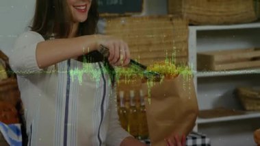 Dişi fırın tezgâhtarı maşa seçiyor, simit seçiyor ve teslimat için kese kağıdına koyuyor. Fırın, esnaf, köy, konukseverlik, perakende, fırın ürünleri, tazelik