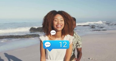 Kumsalda kucaklaşan çift, mesaj sayısı artıyor ve dijital iletişimi simgeleyen sohbet simgeleri oluşturuyor. Romantizm, samimiyet, bağlantı, açık hava, mutluluk, huzur, sevgi