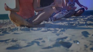 Sahilde meditasyon yapan dört kadın enerji gösteren ışık çizgilerini ve düğümleri aktifleştirerek el ele tutuşuyorlar. Meditasyon, farkındalık, sağlık, dinginlik, maneviyat, sükunet, dijital enerji