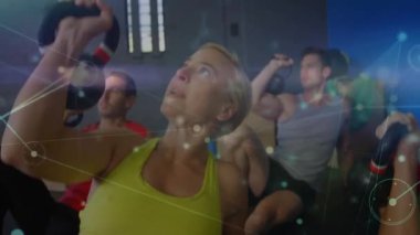 Fitness grubu minderlere yaslanarak üzerlerindeki kettlebell 'leri genişletme hareketini başlatıyorlar. Güç, butik, modern, sağlık, grup, eğitim, teknoloji