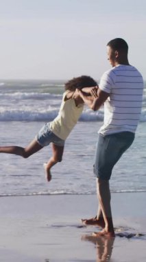 Afrika kökenli Amerikalı baba ve kızı kumsalda olan ışık noktalarının canlandırması. Tatiller, boş zaman ve dijital arayüz kavramı dijital olarak oluşturulmuş video.