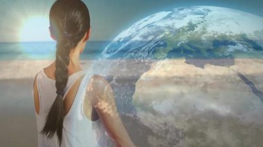 Gün doğumunda kıyıda kayan, gözlerini kapatan ve refah için dönen dünyayı ortaya çıkaran bir kadın. Dinginlik, farkındalık, bağlantı, doğal düşünce, ruhsal uyum.