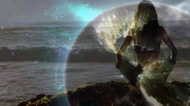 Yogi, kayalık kıyılarda meditasyon yapıyor. Dönüşümlü, parıldayan dünyayı çağırıyor. Farkındalık için kollarını kaldırıyor. Zen, sükunet, dinginlik, dijital, bağlantı, farkındalık, ekolojik