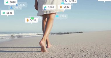 Çıplak ayaklı kadın kıyı şeridinde yürüyor yüzen nişan ikonlarını aktifleştiriyor çevrimiçi nişanı bozuyor. Doğa, sükunet, yaz, açık hava, yaşam tarzı, pozitiflik, minimalizm