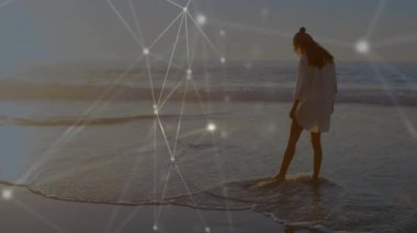 Kadın sörf yapıyor ve ağ kaplamasını başlatıyor. Dijital bağlantıyı gösteren suyun içinde nabız atıyor. Dinginlik, bağlantı, minimalist, yansıtıcı, uyum, teknoloji, huzur