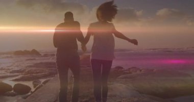 Çift gün batımı rıhtımına adım atıyor. Uçan martıların altında uçarken mercek patlaması yaratıyor. Romantizm, macera, sükunet, siluet, keşif, ufuk, sükunet