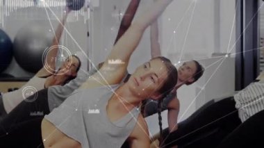 Eğitmenden sonra kadınlar, canlandırmalı grafiklerle fitness yapmak için yan tahtada ilaç toplarını çeviriyorlar. Güç, denge, koordinasyon, sağlık, eğitim, fitness, duruş