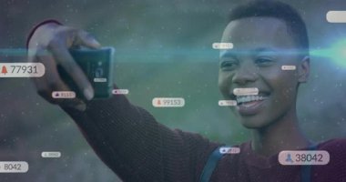 Selfie çekmek için telefonu kaldıran ve ekranda yükselen sosyal medya ölçümlerini izleyen bir kadın. Teknoloji, katılım, nüfuz, dijital, canlı, yaşam tarzı, iletişim