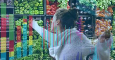 Kadın süpermarkette alışveriş arabası itiyor veri tablolarını aktifleştiriyor ve diyet takibi için yeşil biber topluyor. Market, alışveriş, analitik, sağlıklı, taze, dijital, perakende