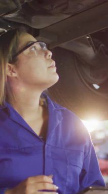 Araba atölyesinde çalışan kadının üzerinde parlayan ışığın animasyonu. Küçük işletme, finans, bilgisayar ve veri işleme kavramı dijital olarak oluşturulmuş video.