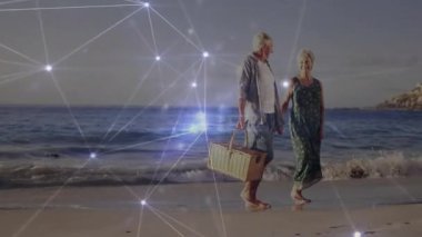 Çerçeveye giriyorlar. Kum üzerinde yürüyorlar. Piknik sepeti taşıyorlar. Romantik, huzur, sağIık, açık hava, boş zaman, bağlantı, dinginlik