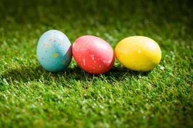 Bahçedeki çimlerin üzerinde renkli Paskalya yumurtaları