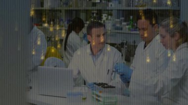 Bilim adamları laboratuvar bilgisayarındaki sonuçları inceliyor, örnek veriyor ve analiz için reaktör ekliyorlar. Araştırma, işbirliği, bilimsel, analitik, teknoloji, yenilik, keşif