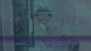 Teknik ekip, statik çizgilerin ortasındaki etiketleri okuyup bağlantıyı onarmak için rafta diz çöküp kabloları inceliyor. Teknisyen, altyapı, kablolama, bağlantı, sorun giderme, bakım, donanım