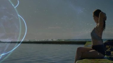 At kuyruğu bağlayan ve kayalık kıyılarda esneyen bir kadın teknoloji dünyasının ortaya çıkmasına ve dönmesine neden oluyor. Sahil şeridi, dinginlik, bağlantı, teknoloji, peyzaj, fitness, yenilik