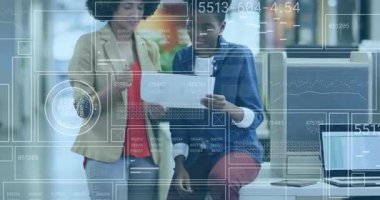 Two business colleagues reviewing report at desk, pointing sections animating data overlays. Collaboration, teamwork, professionalism, analytics, communication, modern, corporate