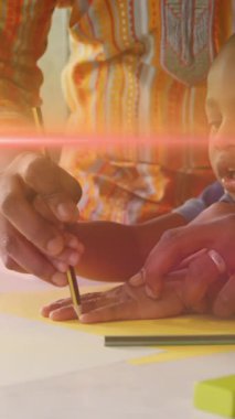 Animation of light flashing over african american father and son drawing hand on paper. Family, parenthood, music and spending time together concept digitally generated video.