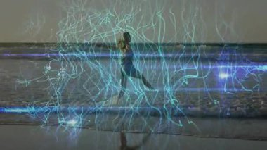 Shoreline dansçısı alacakaranlıkta hareketli enerji hatlarını aktifleştiriyor ve teknoloji entegrasyonunu sergiliyor. Enerjik, fütüristik, akıcı, dinamik, meditasyon, ruhani, modern