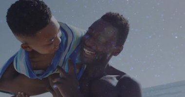 Hayat tarzı bir baba, köpüklü filtrelerle bağ kurmak için oğlunu denizde omuzlarına alıp kaldırıyor. Aile, açık hava, sükunet, neşeli, bağlanma, dinginlik, samimiyet