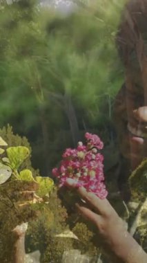 Elinde pembe çiçekler, arka planda ağaç dalları olan bir kadın. Çiçek, doğa, açık hava, buket, kadınlık, huzur