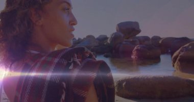 Günbatımı mercekleri alevler içinde yanıyor. Kadın başını uzak kayalara çeviriyor. Seyahat titreşimleri yayıyor. Plaj, siluet, arka plan, doğa, sükunet, macera, manzara