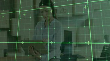 Yeşil teknoloji şebekesi analiz yaparken bir kadın masadaki panoyu inceliyor. Kurumsal, profesyonel, dijital, yenilik, üretkenlik, modern, stratejik