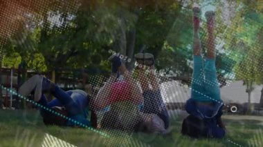 Çocuklar kalçalarını amuda kaldırarak yukarı itiyor ve fitness ile aşağı yuvarlanıyorlar. kılavuz hareketi kaplıyor. Oyun, spor, hareket, açık hava, topluluk, gençlik, dinamik